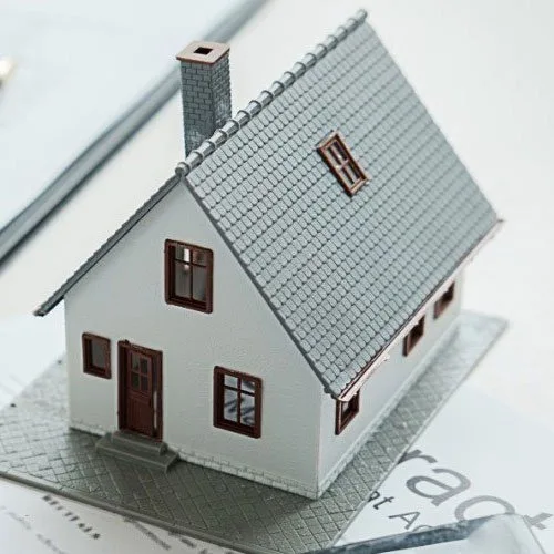 Model house placed on architectural floor plans for property valuation