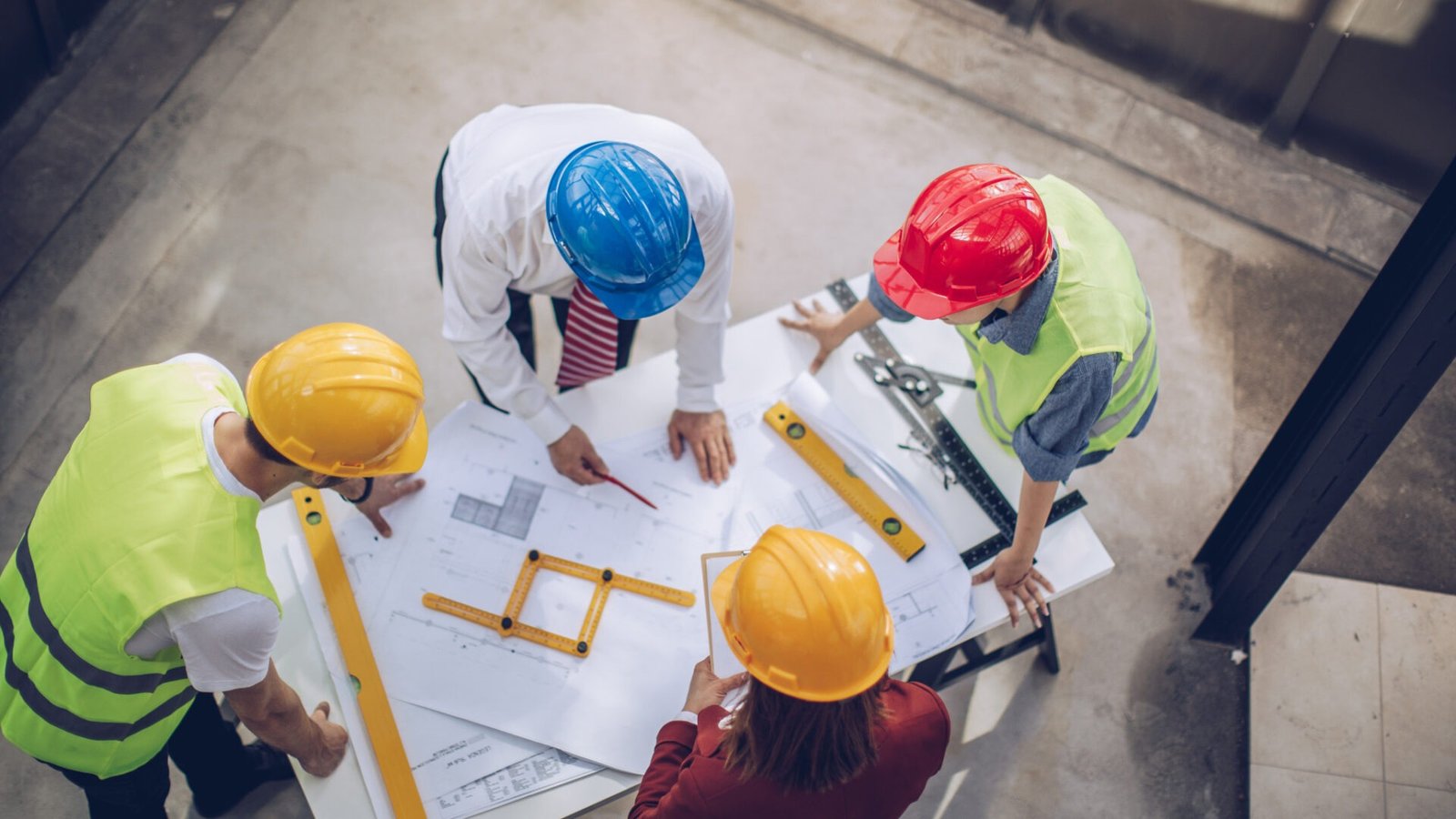 Engineering team in safety helmets reviewing drawings on site – Prospect Infraworld Bhopal