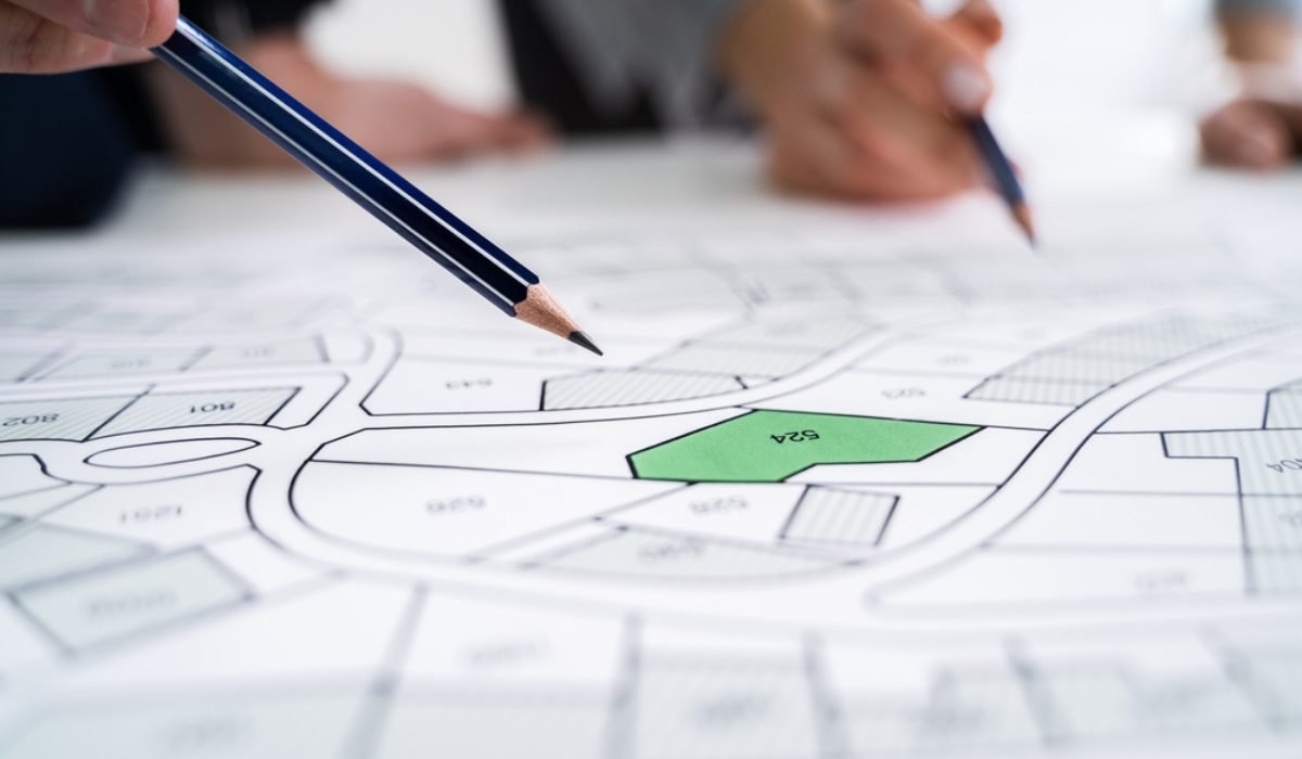 Architects marking a site layout plan with pencil and ruler